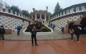 Nauczycielka pozuje do zdjęcia w parku Guell, trzyma w ręku parasol