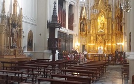 Kaplica przy szkole, w oddali widać dzieci ćwiczące do występu