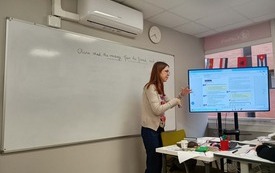 Nauczycielka pokazująca zadanie w języku angielskim na ekranie telewizora