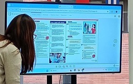 Nauczycielka pokazująca zadanie w języku angielskim na ekranie telewizora