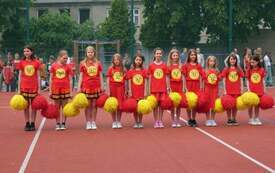 Zesp&oacute;ł cheerleaders na boisku szkolnym 