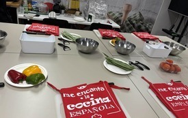 Zdcjęcie stołu, na kt&oacute;rym znajdują się składniki do  paelli oraz przyrządy