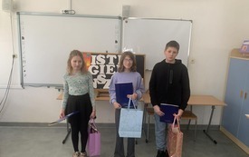 Troje zwycięzkich uczni&oacute;w pozuje do zdjęcia z nagrodami