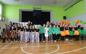 Uczestnicy pozują do grupowego zdjęcia na sali gimnastycznej