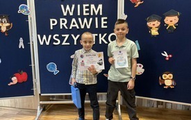 Dwaj chłopcy trzymają w ręku dyplomy