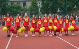 Zesp&oacute;ł cheerleaders na boisku szkolnym 