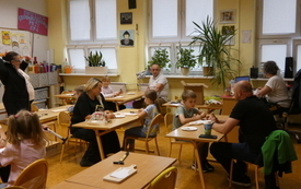 Zdjęcie sali, w kt&oacute;rej rodzice z dziećmi wykonują dekoracje na desce kuchennej