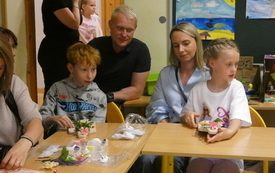 Dzieci z rodzicami siedzą przy stoliku