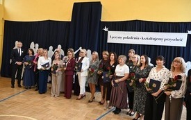 Nauczyciele stojący na sali gimnastycznej, kt&oacute;zy otrzymali nagrody