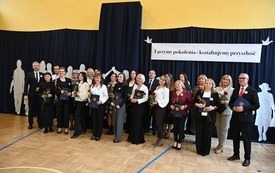 Nauczyciele stojący na sali gimnastycznej, kt&oacute;zy otrzymali nagrody