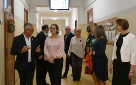 Grupa ludzi zwiedzająca szkołę