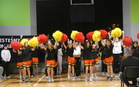 Zesp&oacute;ł cheerleaders występuje na sali gimnastycznej