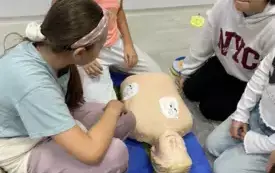 Dzieci ćwiczą udzielanie pomocy na fantomie