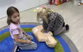 Dziewczynki trenują udzielanie pomocy na manekinie