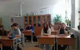 Uczniowie siedzą w ławkach i oglądają film