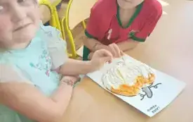 Chłopiec i dziewczynka wyklejają dynie