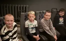 Uczniowie siedzą w planetarium