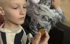 Uczeń trzyma w ręku meteoryt