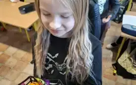Uczennica prezentuje pomalowane dynie