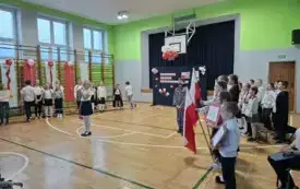 Uczniowie śpiewają pieśń, jeden z chłopc&oacute;w przebrany za J&oacute;zefa Piłsudskiego