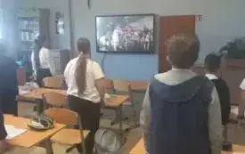 Uczniowie stoją tyłem, śpiewają hymn