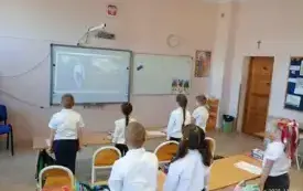 Uczniowie stoją tyłem, śpiewają hymn