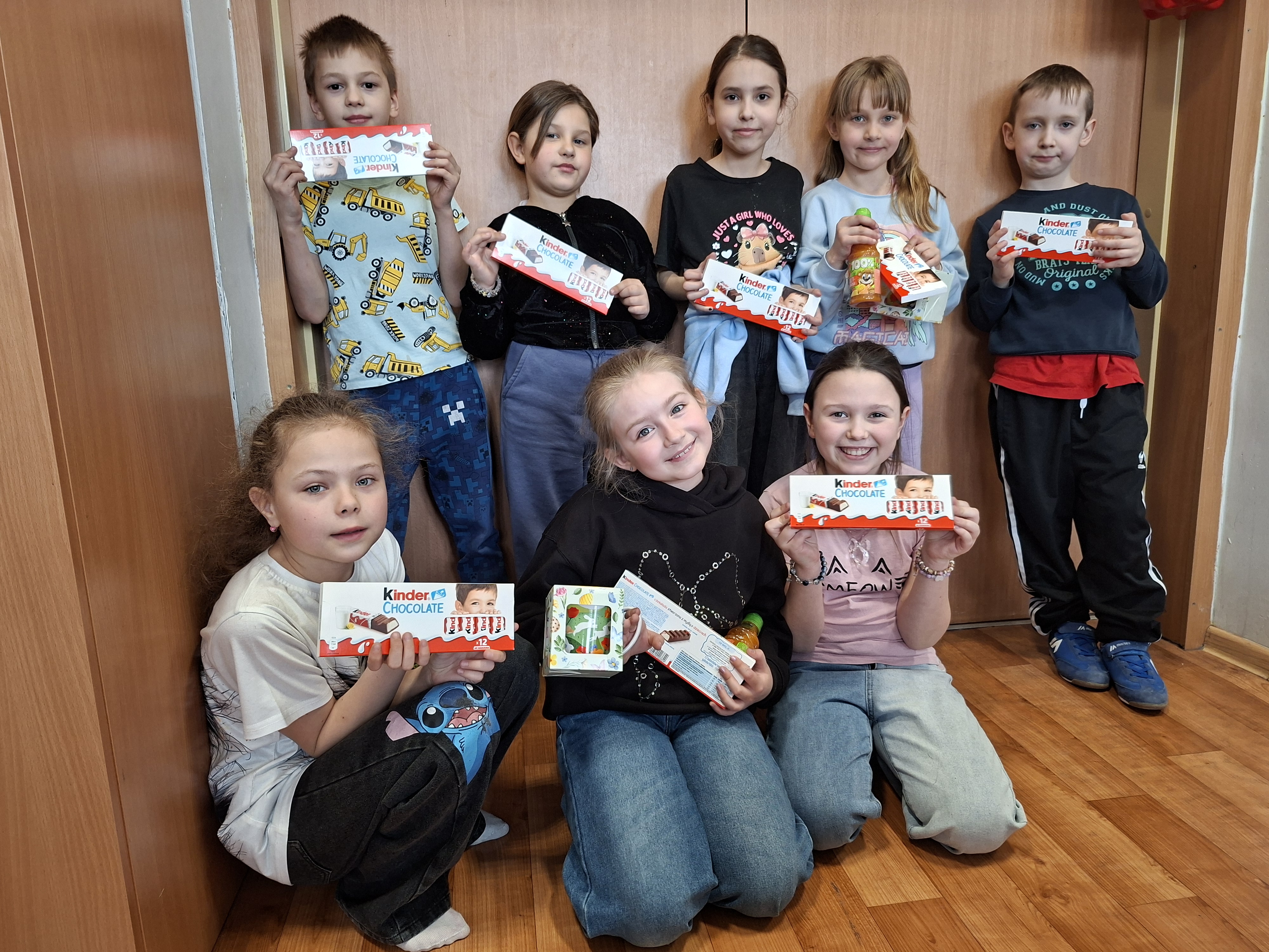 Kilkoro dzieci pozuje do zdjęcia, trzymają w&nbsp;ręku czekoladki