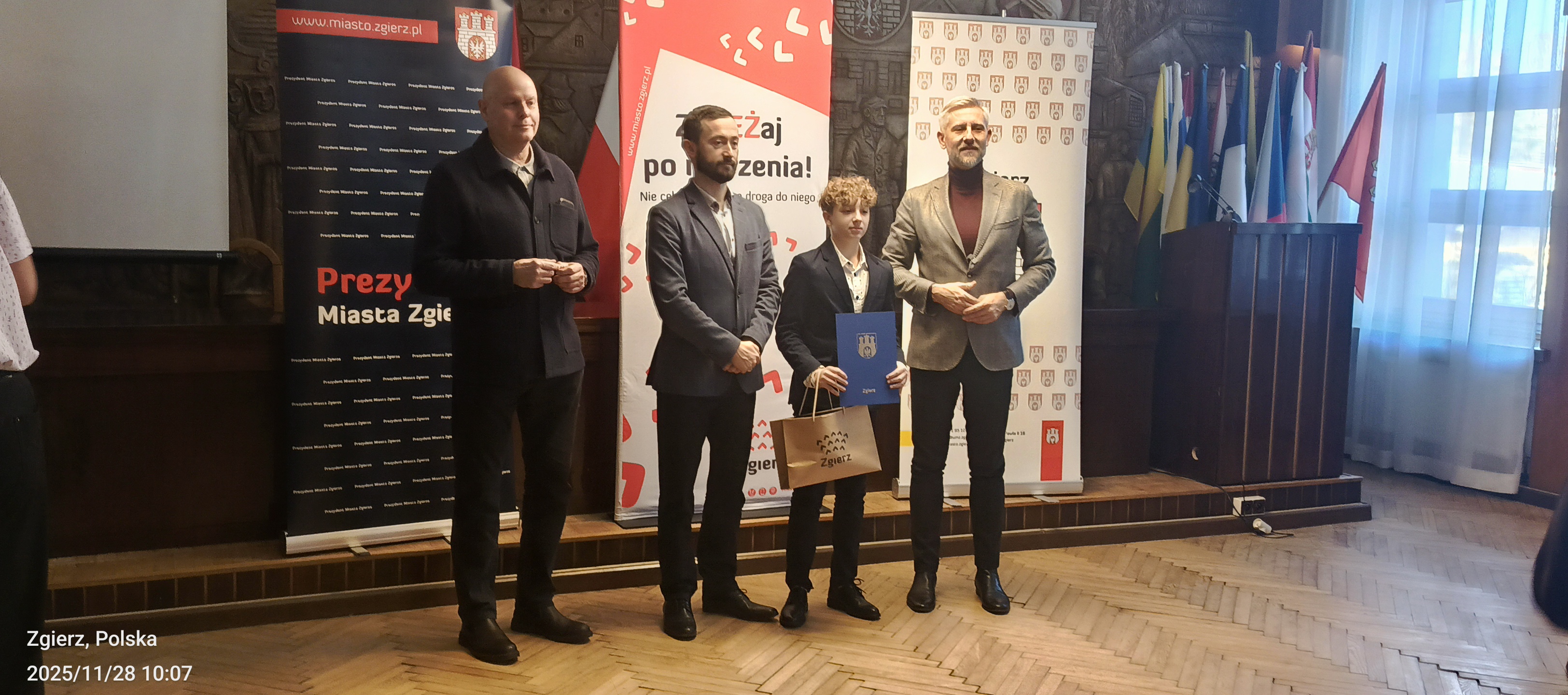 Uczeń stoi obok Sekretarza i&nbsp;Prezydenta Miasta Zgierza