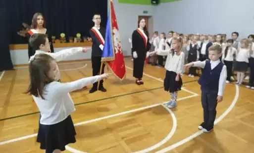  Uczniowie wyciągają rękę i wygłaszają tekst ślubowania