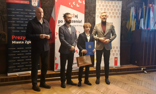 Uczeń stoi obok Prezydenta i Sekretarza Miasta Zgierza