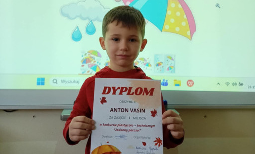 Chłopiec trzyma w rękach dyplom