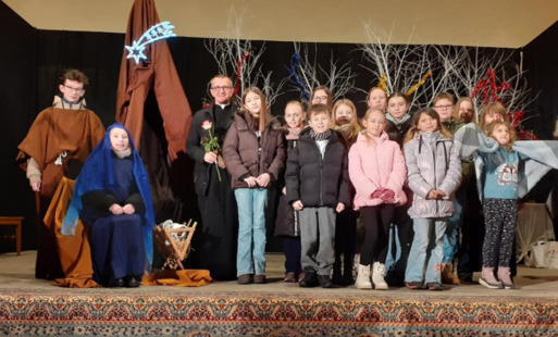 Drugie zdjęcie zostało zrobione w sali "Przystań" przy parafii św. Katarzyny. Na zdjęciu ksiądz proboszcz i dzieci biorące udział we wspólnym kolędowaniu.