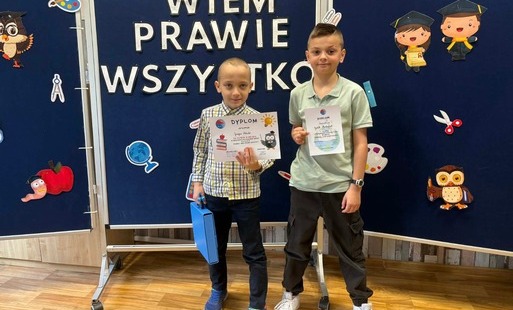Dwaj chłopcy trzymają w ręku dyplomy