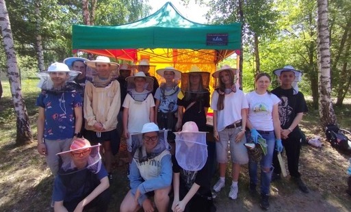 Grupa 16 uczniów w strojach i sprzętem do paintballa